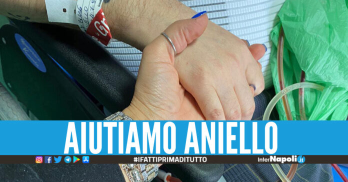 Aniello mentre stringe la mano della compagna